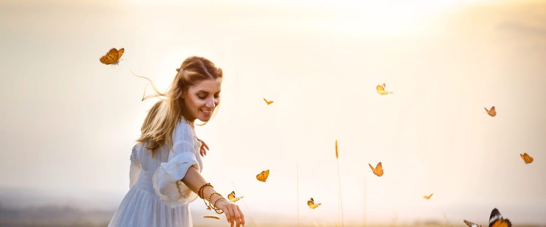 Girl in meadow with flitting butterflies
